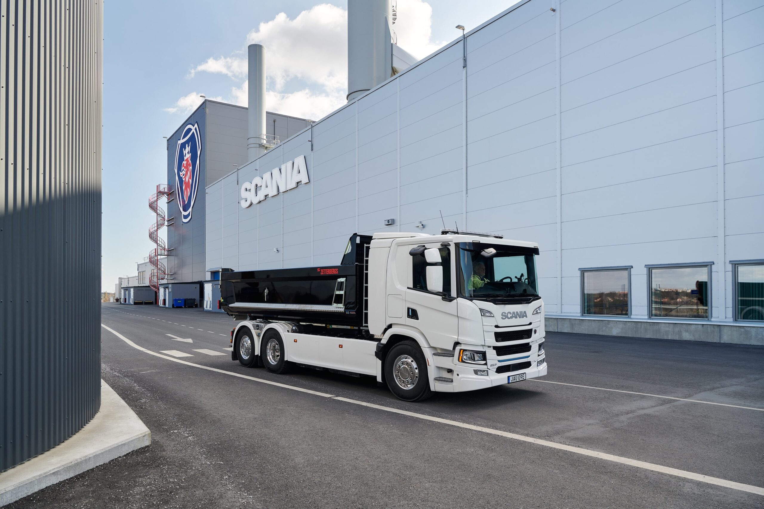 En vit lastbil från Scania körs på fabriksområdet på Scania i Södertälje.
